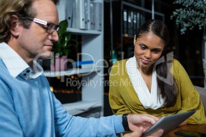 Business executives discussing over digital tablet