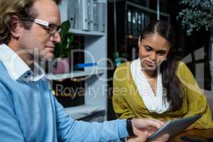 Business executives discussing over digital tablet