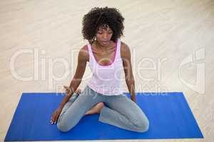 Woman performing yoga on exercise mat