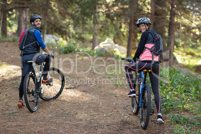 Biker couple with mountain bike in countryside
