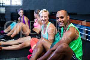 Smiling male and female athletes in fitness studio