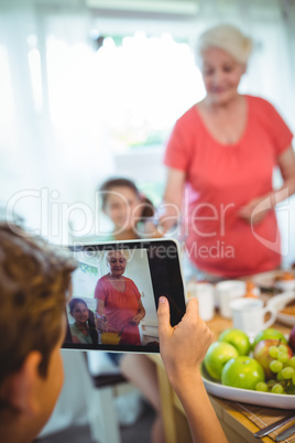 Boy photographing his grandmother and sister