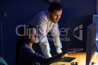 Businesswoman discussing with colleague over digital tablet