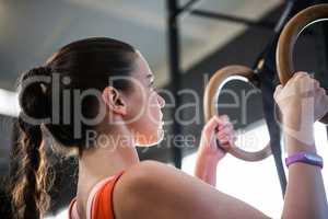Low angle view of female athlete holding gymnastic rings