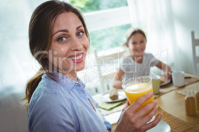 Woman having a glass of orange juice at home