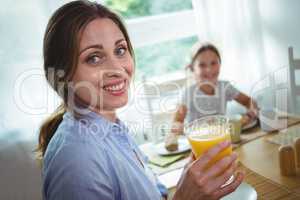 Woman having a glass of orange juice at home