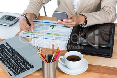 Mid section of businesswoman writing on document