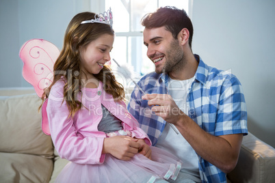 Girl dressed up in a fairy costume interacting with father