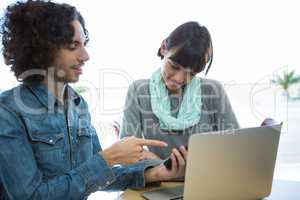 Couple using mobile phone with laptop on table