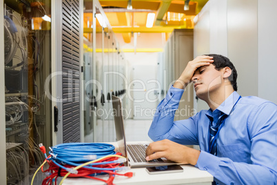 Stressed technician working laptop