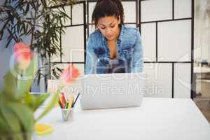 Businesswoman using laptop at desk