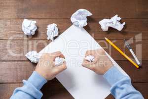 Man crumpling paper while writing notes