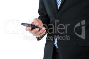 Mid section of businessman text messaging on mobile phone