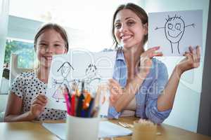 Mother and daughter showing their drawings