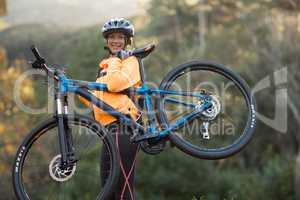 Female biker carrying mountain bike