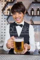 Barmaid serving glass of beer