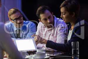 Businesswoman discussing on digital tablet with her colleagues