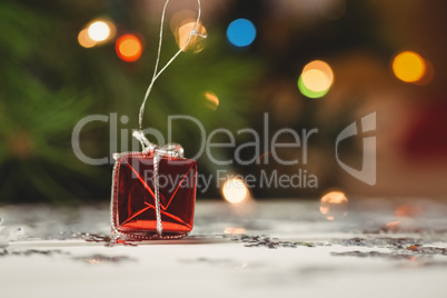 Small wrapped gift box and snowflake scattered on wooden table