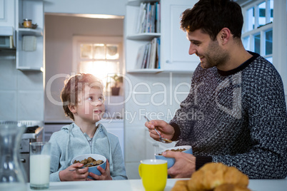 Father and son having breakfast in the kitchen