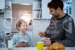 Father and son having breakfast in the kitchen