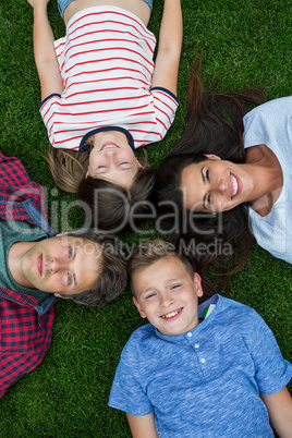 Happy family lying on grass in park