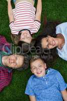 Happy family lying on grass in park