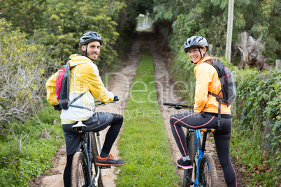 Biker couple with mountain bike in countryside track