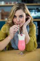 Portrait of woman drinking milkshake with a straw
