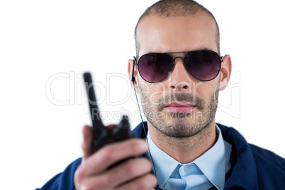 Handsome security officer talking on walkie-talkie