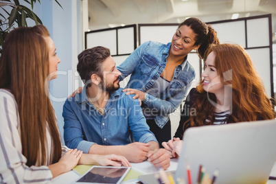 Businessman with happy female coworkers at desk Businessman with happy female coworkers at desk