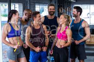 Smiling friends with jumping ropes in gym