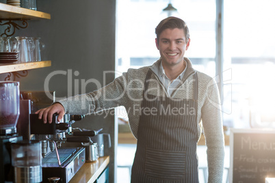 Smiling waiter standing in kitchen at cafÃ?Â©