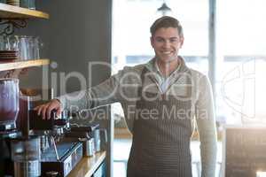 Smiling waiter standing in kitchen at cafÃ?Â©