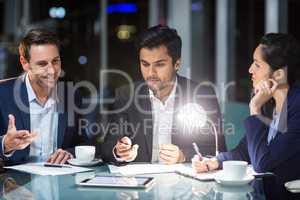 Group of businesspeople discussing over digital tablet