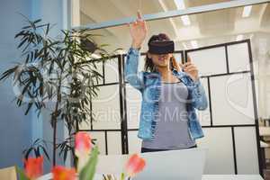 Businesswoman gesturing while using virtual reality headset