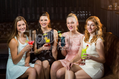 Female friends holding glasses of cocktail in bar