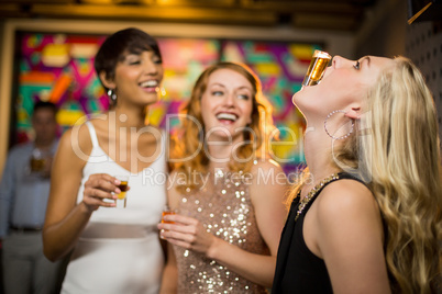Woman balancing a shot glass on her mouth