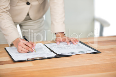 Businesswoman filling insurance contract form in office