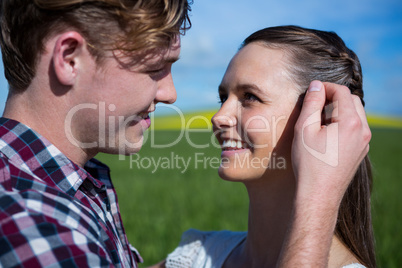 Romantic couple looking at each other in field