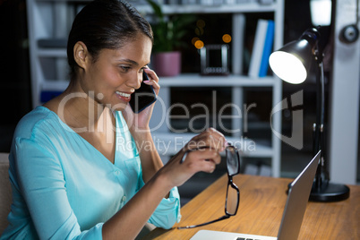 Businesswoman talking on mobile phone in office
