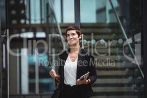 Smiling businesswoman holding digital tablet