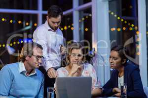 Businesspeople having discussion over laptop