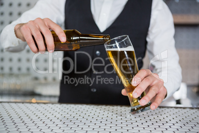 Bartender pouring beer on glass