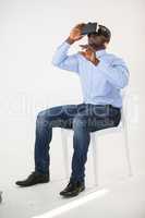 Man sitting on chair and using virtual reality headset