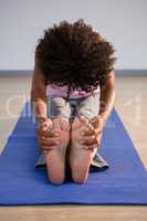 Woman doing seated forward on bend exercise mat