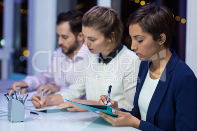 Businesspeople preparing document in office