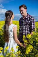 Romantic couple looking at each other in mustard field