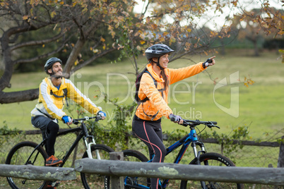 Biker couple cycling and pointing in distance