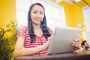 Portrait of happy beautiful executive using tablet at creative office