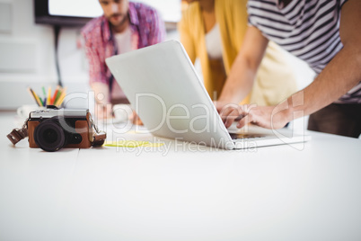 Close-up of camera on desk with professionals working at office